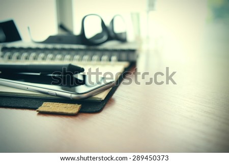 Smart phone close-up,  planning book on wooden desk work space concept