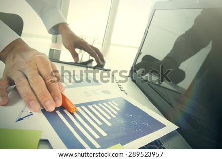 businessman hand picking up the pen at office and social network media and graph chart diagram as concept