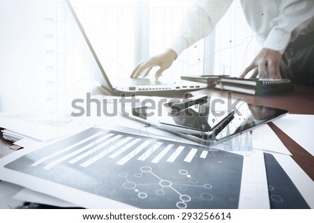 business documents on office table with smart phone and digital tablet and graph business diagram and man working in the background with business graph diagram