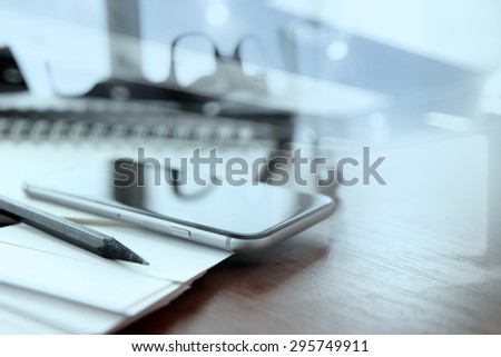 business documents on office table with smart phone and digital tablet as workspace business