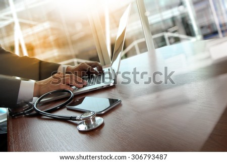 Doctor working at workspace with laptop computer in medical workspace office and medical network media diagram as concept