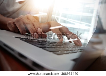 business man hand working on laptop computer on wooden desk as concept, young man student typing on computer sitting at wooden table