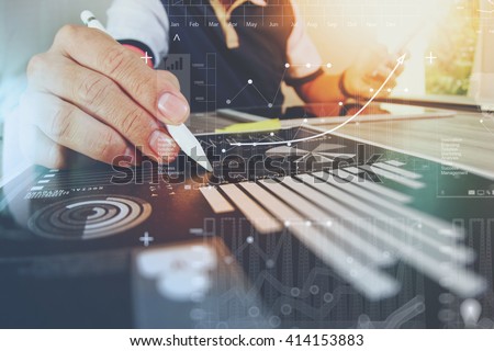 Photo of business documents on office table with smart phone and digital tablet and graph financial with social network diagram and man working in the background