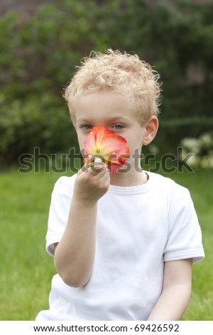Young boy is trying to figure out what his nose will find.