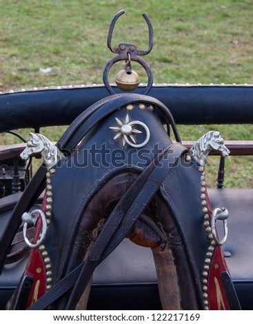 Vintage horse collar decorated with two iron horse heads, rivets and the bell.