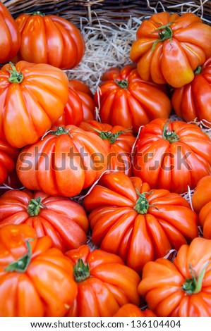 Shiny ripe beefsteak tomatoes at farmers market in Paris.