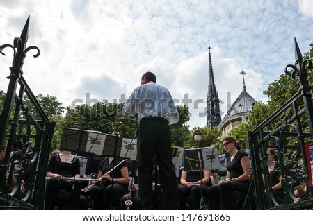PARIS - JULY 6: Unidentified musicians play classical music in park near Notre Dame church on July 6, 2013 in Paris, France. In summer Paris offers a variety of entertainment to citizens and tourists.