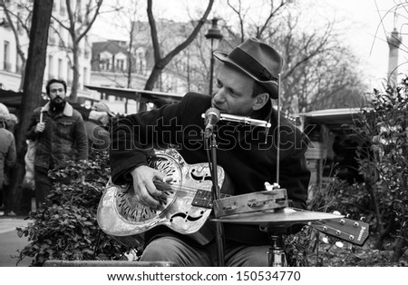 PARIS - MARCH 10: Blues-rock guitarist Rene Miller playing his Dobro guitar at street market on March 10, 2013 in Paris, France.