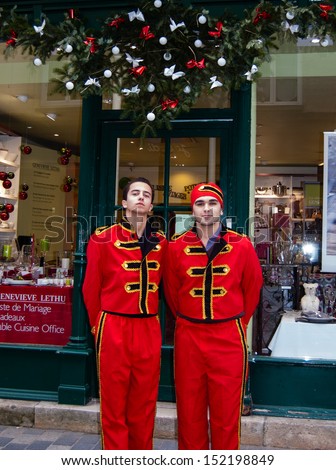 SENLIS, FRANCE - DEC 24: Two unidentified delivery men in red uniform near a shop on December 24, 2012 in Senlis, France. In Christmas Eve Senlis\' shops propose such festively dressed delivery men.