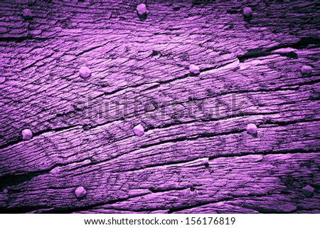 Old violet wooden texture with nail heads and cracks. Shadowed angles.