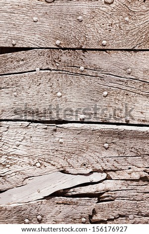 Old gray wooden texture with nail heads and cracks.
