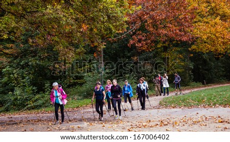 PARIS, FRANCE - OCTOBER 26, 2013: Unidentified people walk with sticks (Nordic walking) in Vincennes park. Medical studies show that walking can reduce the risk of the stroke in elderly people.