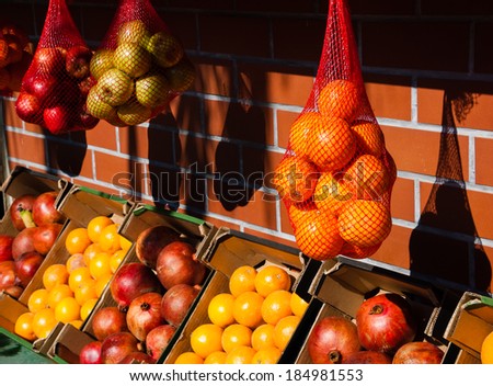 Oranges, grapefruits, apples and pomegranates at the  fresh juice stall in Jaffa (Israel). Contrast of bright sunshine and dark shadows. Selective focus on the oranges in mesh bag at the right. Foto stock © 