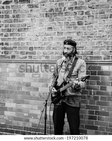 LONDON, ENGLAND, UK - MAY 4, 2014: Street musician play electric guitar near Columbia Road Flower Market.  Dozens buskers perform on the streets of London.