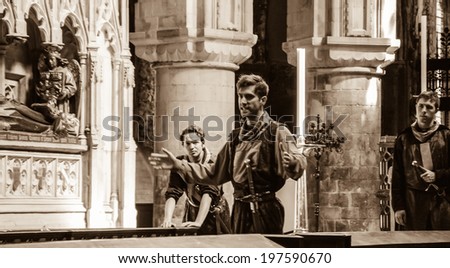 LONDON, ENGLAND, UK - MAY 6, 2014: Unidentified young actors rehearse (worn in costumes of medieval knights) in Church of St Bartholomew the Great.  This Anglican church was established in 1123.