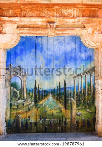 ROUSSILLON, FRANCE - MAY 13, 2013: Painting of French garden with ruins of  Roman temple on door of old house. Roussillon ocher village is included in list of \