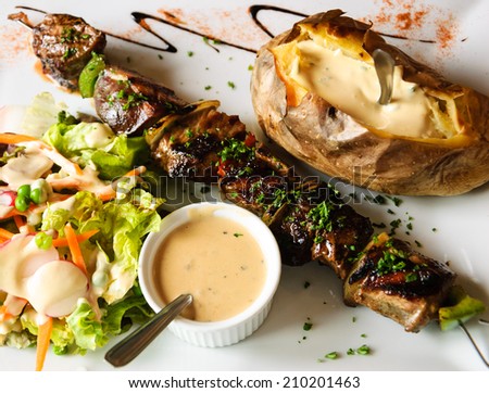 Delicious beef and duck kebab with fresh green salad, baked potato and French pepper cream sauce.