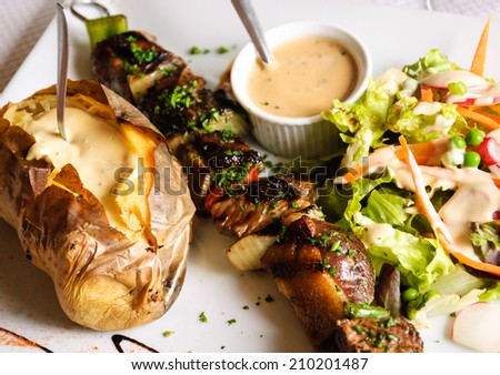 Delicious beef and duck kebab with fresh green salad, baked potato and French pepper cream sauce.