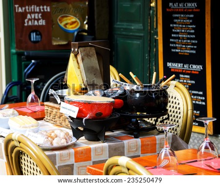 PARIS, FRANCE - OCTOBER 5, 2014: Fondue Savoyarde and Raclette displayed (to attract customers) in typical traditional restaurant. Latin Quarter known for its restaurants serving traditional dishes.