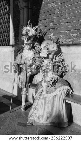 VENICE, ITALY - FEBRUARY 16, 2015:Two masks in sunlight near Doge\'s Palace in St Mark\'s Square during traditional Carnival. The Carnival in Venice is annual event which ends on Shrove Tuesday.