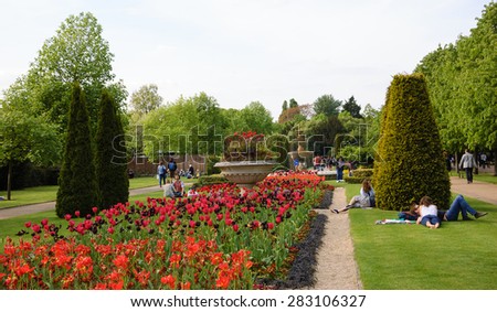 LONDON, ENGLAND, UK - MAY 4, 2014: Tourists and citizens relaxing in Queen Mary\'s Garden in Regent\'s park. Queen Mary\'s Gardens were opened to the public in 1932.