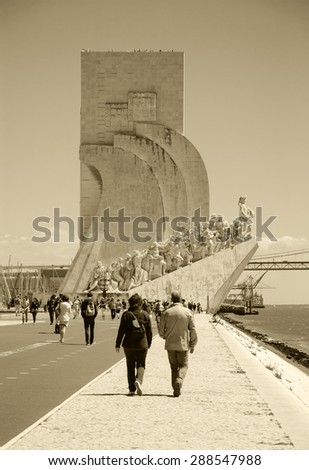 LISBON, PORTUGAL - APRIL 22, 2015: Tourists visit the Monument to the Discoveries (Padrao dos Descobrimentos) over Tagus River in Belem quarter. Aged photo. Sepia.