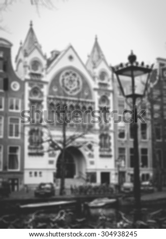 Amsterdam houses over the canal, streetlight, bikes and boats. Blurred aged photo. Black and white.