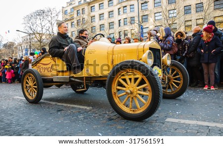 PARIS, FRANCE - JANUARY 1, 2015: Antique yellow Ford car participates in New Year Parade on Avenue des Champs-Elysees. Colorful New Year Parade is annual event.