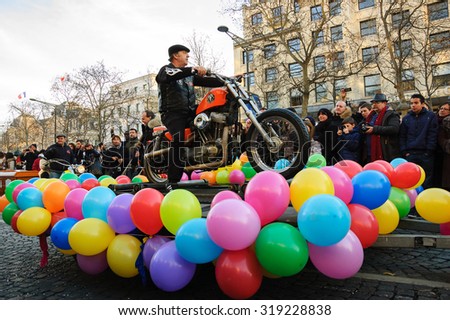 PARIS, FRANCE - JANUARY 1, 2015: Motorbike rider on balloon decorated platform participates in New Year Parade on Avenue des Champs-Elysees. Colorful New Year Parade is annual event.