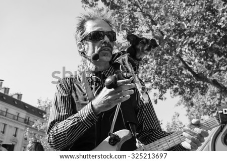 PARIS, FRANCE - OCTOBER 3, 2015:  Unidentified musician and his dog play and sing amusing the participants of Zombie parade at Place de la Republique. Zombie Walk is an annual event in Paris.