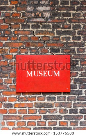 Red Museum Sign attached to a brick wall