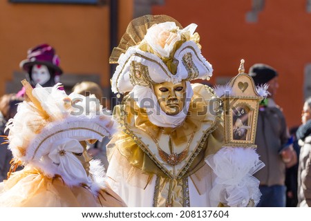 SCHWAEBISCH-HALL, GERMANY - February 23, 2014 - A couple, dressed up in a Venetian style costume with golden masks attend the Hallia Venetia Carnival festival on February 23, 2014 in Schwaebisch-Hall.