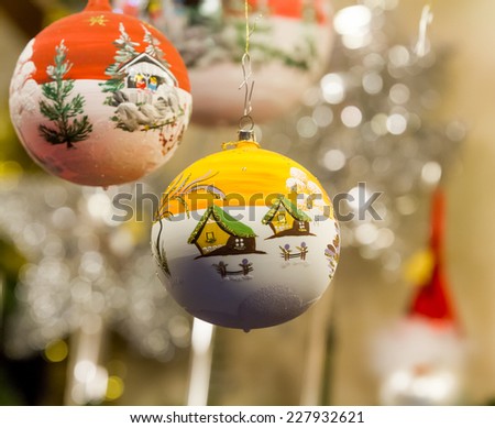 Two different Christmas ornaments, depicting winter landscapes
