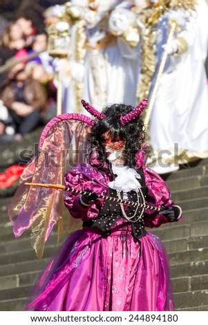 SCHWAEBISCH-HALL, GERMANY - February 23, 2014 - Woman, dressed up in a Venetian style costume as purple devil attends the Hallia Venetia Carnival festival on February 23, 2014 in SchwÃ?Â¤bisch-Hall.