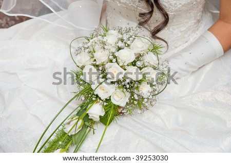 white fine rose in wedding bouquet in hand