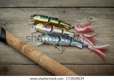 lot of colorful lures with the fishing rod on the wooden pier