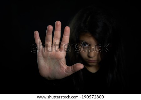 Children violence. Girl with her hand extended signaling to stop.