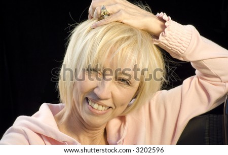 Beautiful blond woman sitting scratching top of head