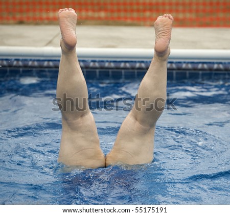 Human legs sticking straight out of water
