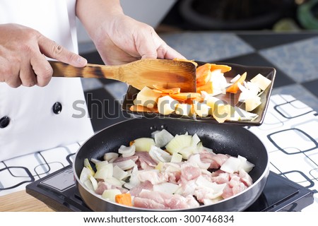 Chef putting vegetable to the pan for cooking Japanes pork curry / cooking Japanese pork curry concept
