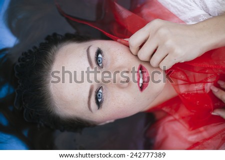 Close-up portrait of a beautiful woman floating on the water
