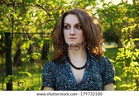 red-haired curly pensive woman with amber eyes  near the grapes at sunny day