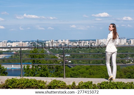 pretty young woman enjoying city view from balcony