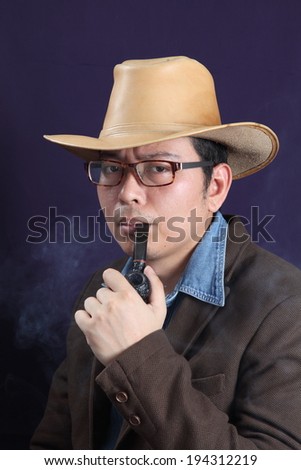 Smoking a pipe. Portrait of handsome young man in hat smoking a pipe