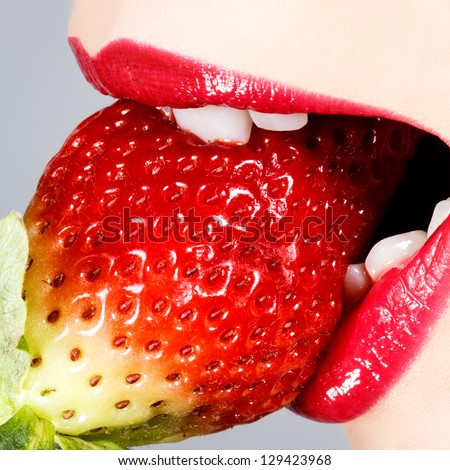 Beautiful juicy strawberry and female lips, macro photography
