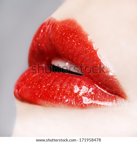 Beautiful female with red shiny lips close up