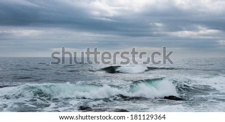 Breaking ocean waves and stormy sky
