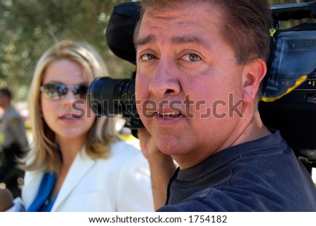 Television news cameraman with female reporter