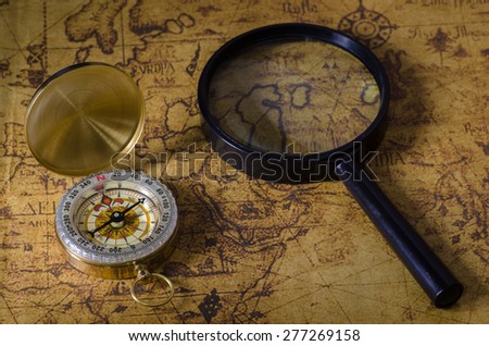 Compass and magnifying glass on old map