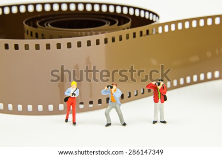 Miniature photographer with photo film background